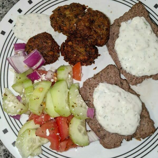 Plate containing Greek Cucumber Salad, Falafel, Tzatiki Sauce, and Lamb and Ground Beef Gyros