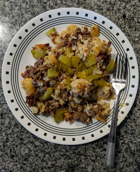 Bacon Cheeseburger Tatertot Casserole topped with pickles.