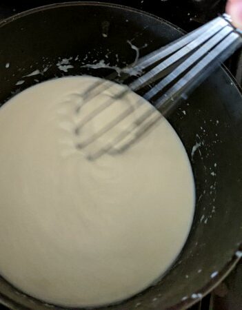 Bechamel Sauce being whisked in pan