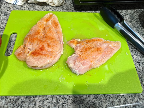 Spinach Stuffed Chicken Breast - Seasoned chicken on cutting board pre baking.