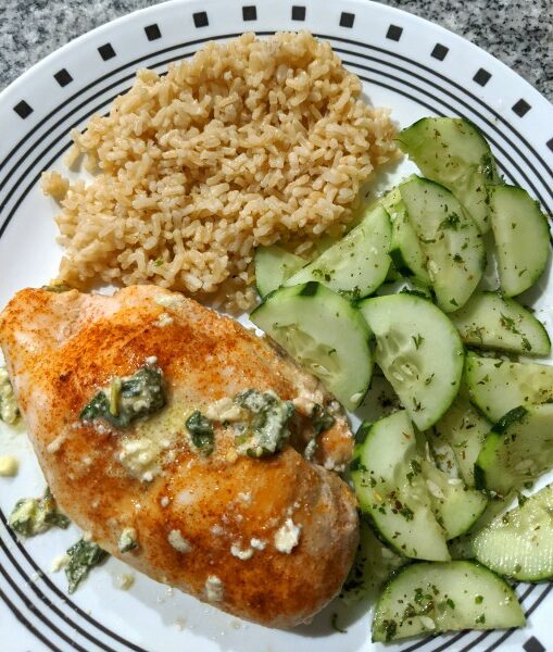 Spinach Stuffed Chicken Breast with Rice and Cucumber Salad on Plate

