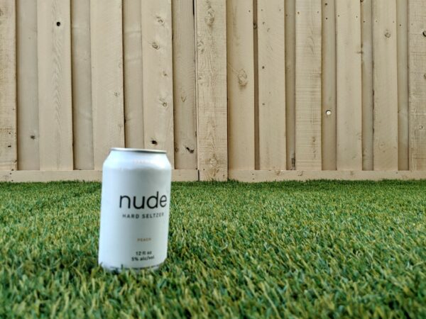 Peach Nude Hard Seltzer can in grass