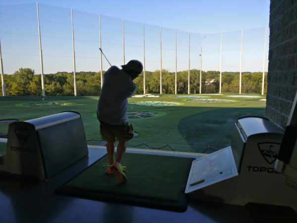 Man golfing at Top Golf Kansas