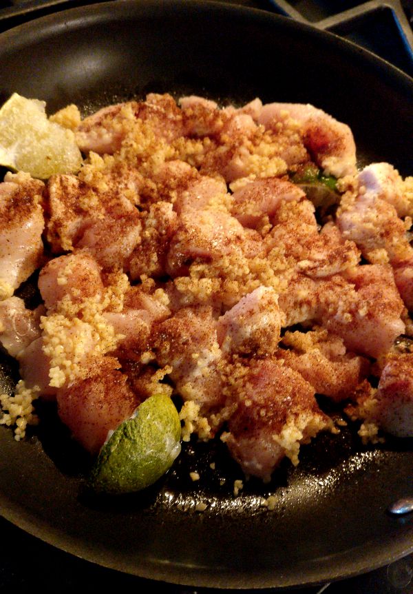Chicken cooking in pan. Chicken is seasoned with with garlic, lime, chili powder, and salt.