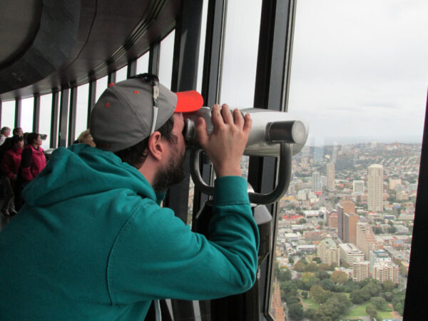 Matt looking through binoculars at Sydney Tower Eye Observation Deck