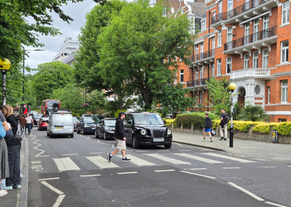 Man crossing the intersection at Abbey Road in London in St. John's Wood