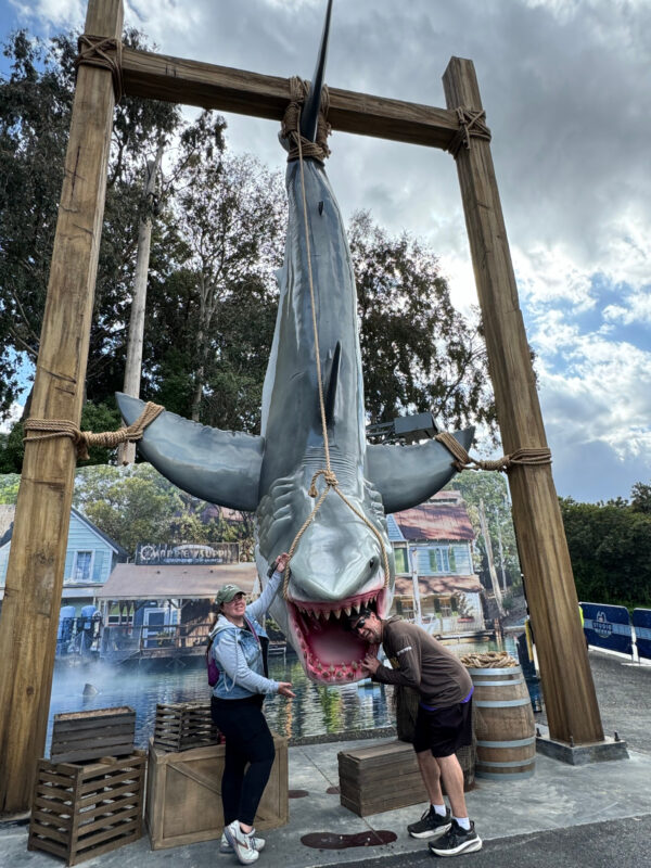 Couple poses with Jaws after being caught at Universal Studios 60th Anniversary special walk through area at Universal Studios Hollywood