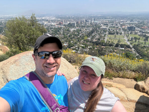 Couple posing at top of Mt. Rubidoux with view of downtown Riverside, CA in the background