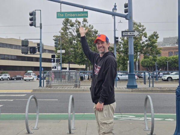 Man pointing at The Embarcadero Sign